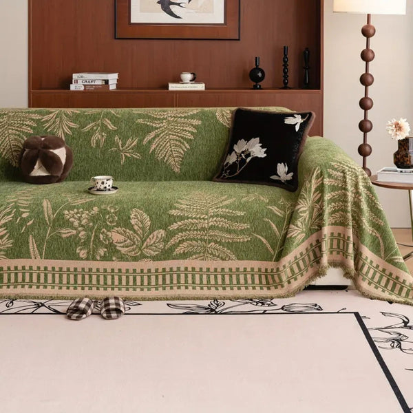 Botanical floral chenille sofa cover in Midnight Fern draped over a three-seater sofa in a warm living room setting