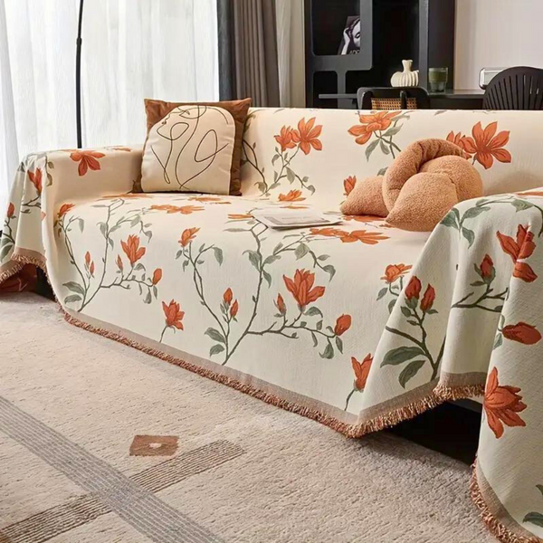 Close-up of magnolia floral pattern and chenille texture on vintage sofa cover in warm beige and orange tones
