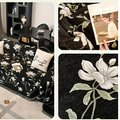 Vintage floral chenille throw in black and white colorway displayed on a neutral-toned linen couch