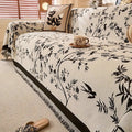 Full view of olive green chenille throw covering a sectional sofa in a bright, naturally lit living space