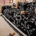 Tasseled chenille sofa cover in garden beige folded neatly over a loveseat armrest with earthy home decor accents
