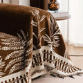 Side angle of the chenille sofa cover showing drape, weight, and warm-toned floral pattern in a styled room