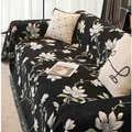 Green and white floral chenille sofa cover layered over a modern sofa with decorative pillows