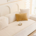 Plush sofa cover in Cream Cloud neatly fitted over a three-seater couch with textured throw pillows
