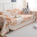 Rusty orange chenille flowerfield sofa cover displayed across a linen-upholstered couch with earthy decor accents
