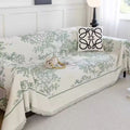 Soft mint green chenille floral throw cover styled on a reading nook armchair beside a ceramic vase