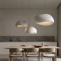 Wabi-sabi pendant light with organic textured shade hanging above a dining table in a warm-toned interior
